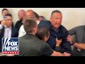 BREAKING: Senator hauled away from Noem's press conference after fiery confrontation