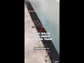 Dad holds son under moving train
